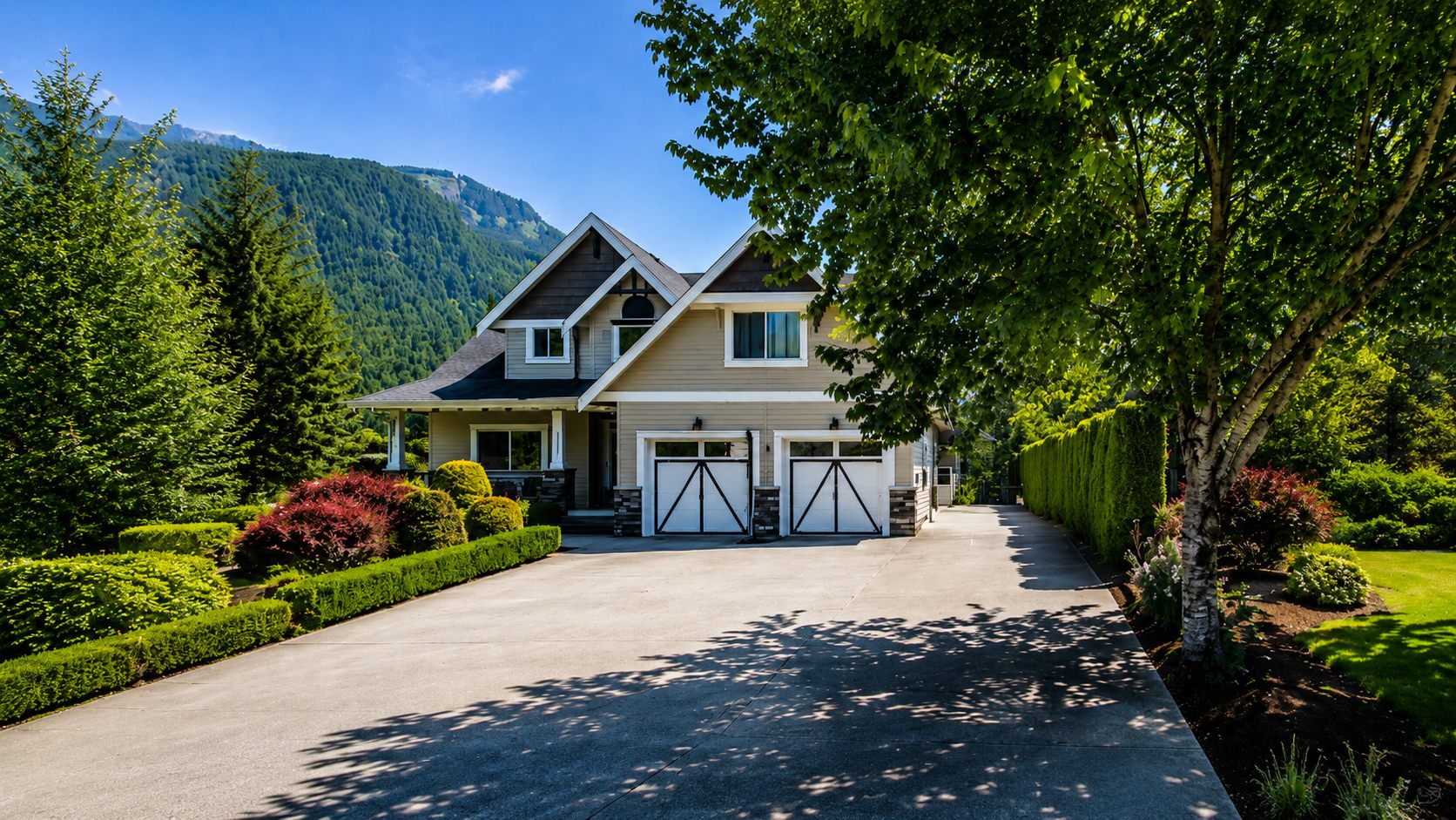 Two-storey home with double garage against a mountain backdrop